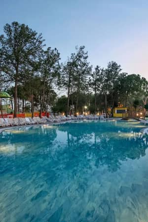 Outdoor swimming pools and aquapark at Megasaray Resort Side in the evening.