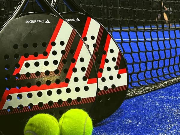 Padel rackets and balls beside the net at Advantage Padel Nottingham