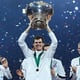 British tennis team celebrate as a player lifts the Davis Cup trophy, confetti falling.